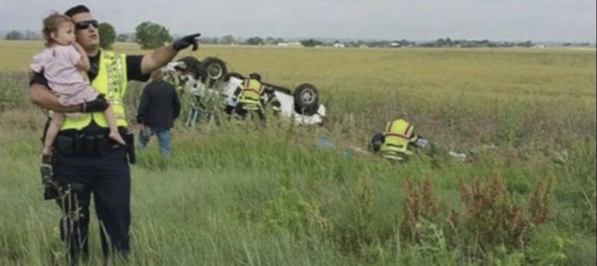 Police officer pictured distracting a little girl after her father lost his life in a car accident